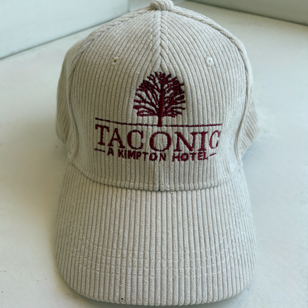 Beige cap with red logo and text on a white surface